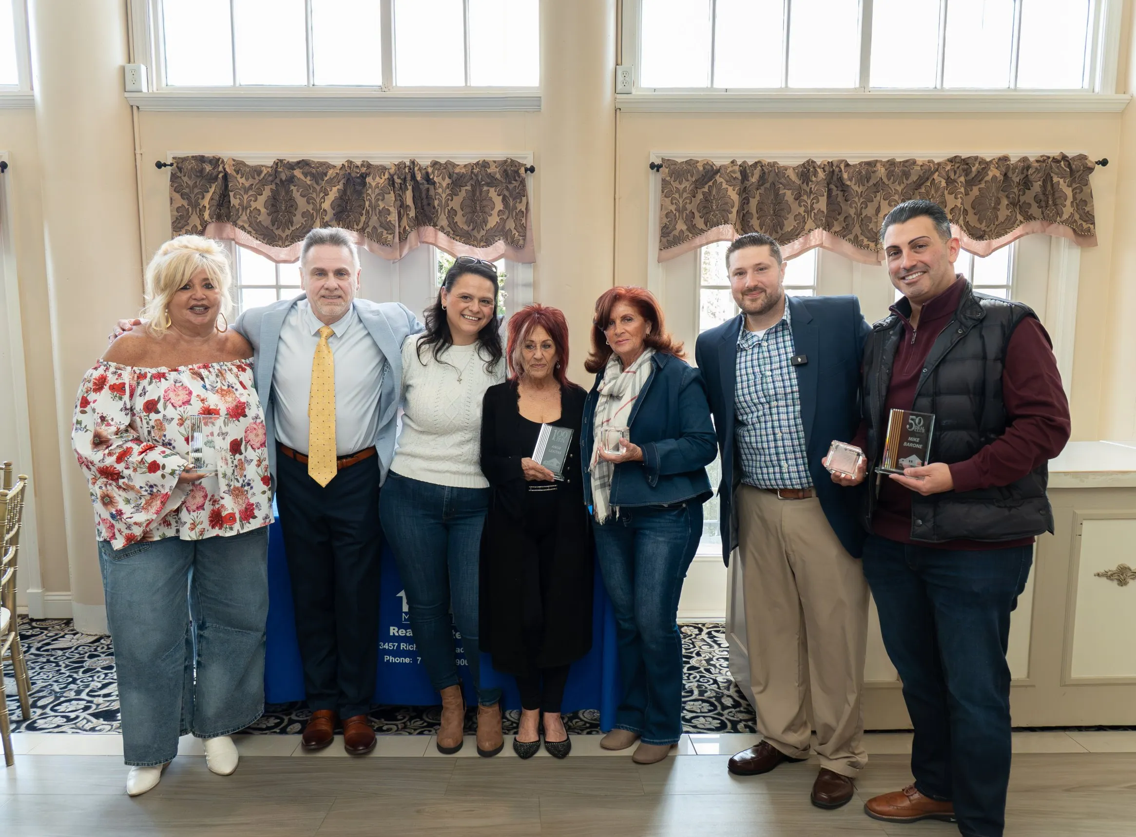 M. Donato & Company agents standing together holding their sales awards